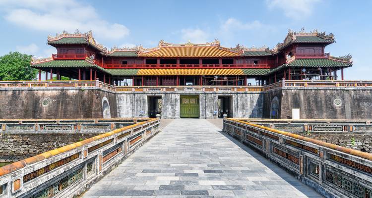 A historic gateway and bridge leading to a palace.