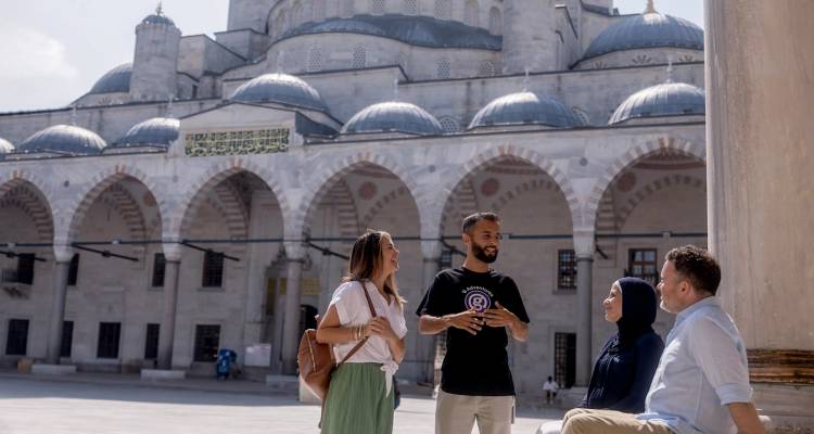 Gids praat met bezoekers op de binnenplaats van de Blauwe Moskee in Istanbul.