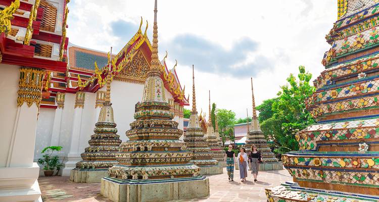Des gens marchant à travers un complexe de temples aux décorations ornées.