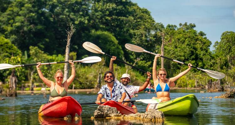 Kayak en groupe sur un lac avec de la verdure en arrière-plan.