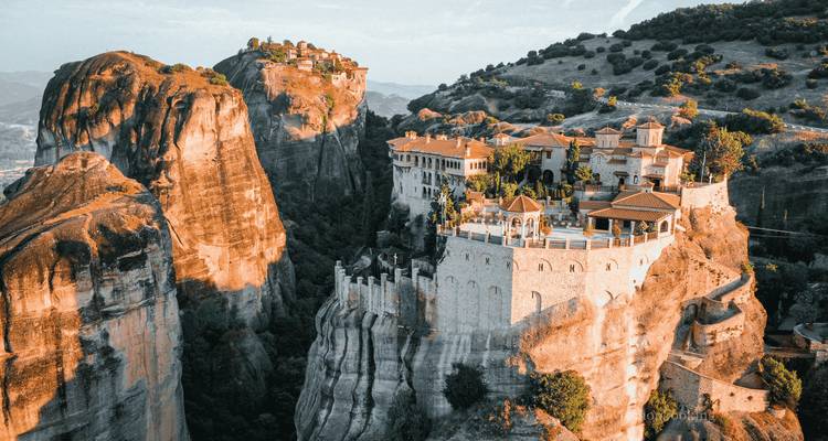 Vue aérienne dramatique du monastère des Météores perché sur d'imposantes falaises de grès à la lumière de l'aube
