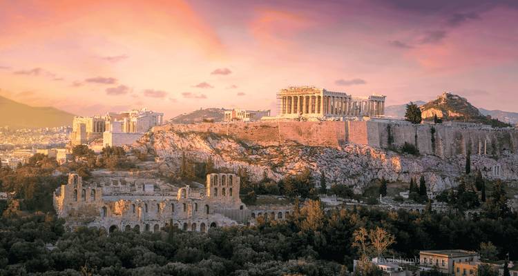 Panorama du coucher de soleil d'Athènes montrant l'Acropole et le Parthénon brillant au-dessus de la ville