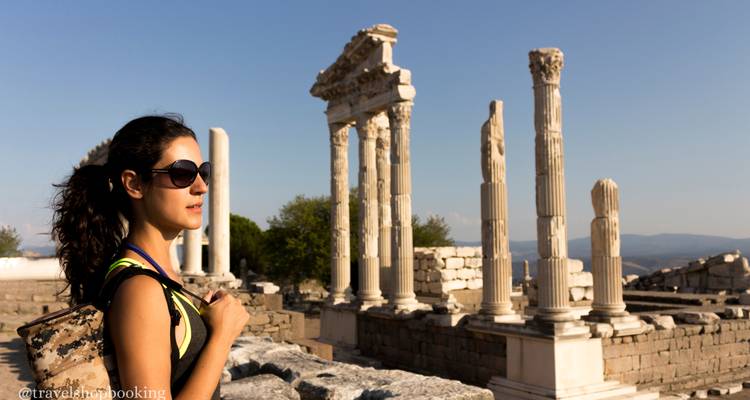Voyageuse avec sac à dos debout à côté des colonnes antiques de Pergame dans la lumière de fin d'après-midi