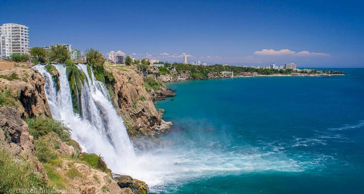 De Düden-watervallen vallen in cascades over kliffen de zee in naast Antalya's moderne kustlijn.