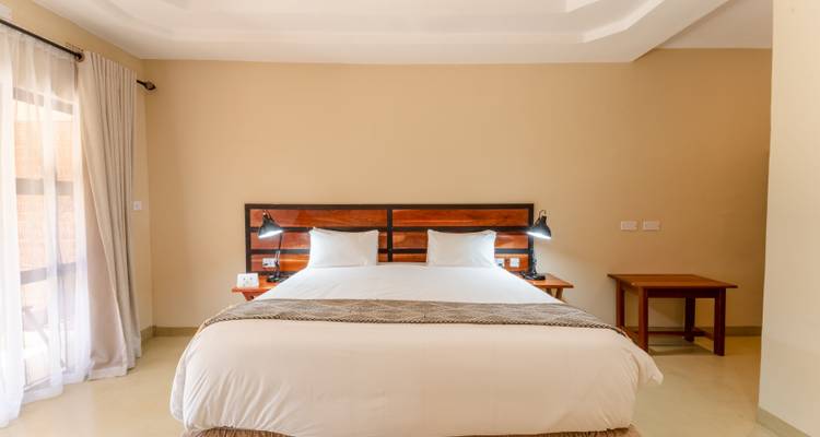 Hotel room with a large bed and side tables.