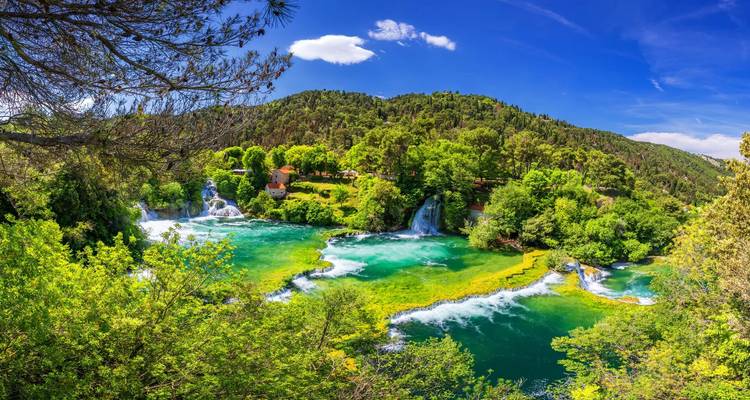 Üppige grüne Landschaft mit Wasserfällen und kleinen Seen.