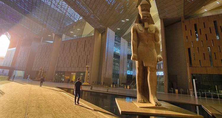 Große Statue in einem modernen Gebäude mit gehenden Menschen.