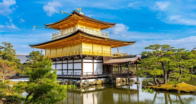 Pavillon doré entouré d'un étang et d'arbres.
