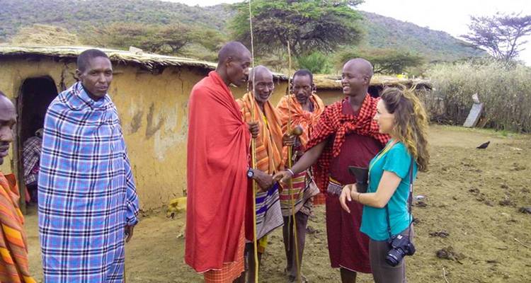 Tourist interacting with local people wearing vibrant traditional attire.