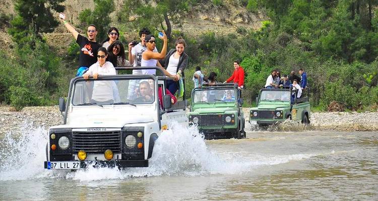 Groupe de personnes en safari en jeep traversant un ruisseau.