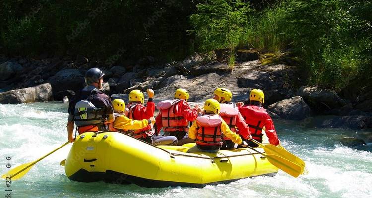 Groupe de personnes faisant du rafting sur une rivière avec équipement de sécurité.