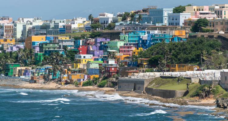 Kleurrijke gebouwen aan de kust en brekende golven in San Juan.