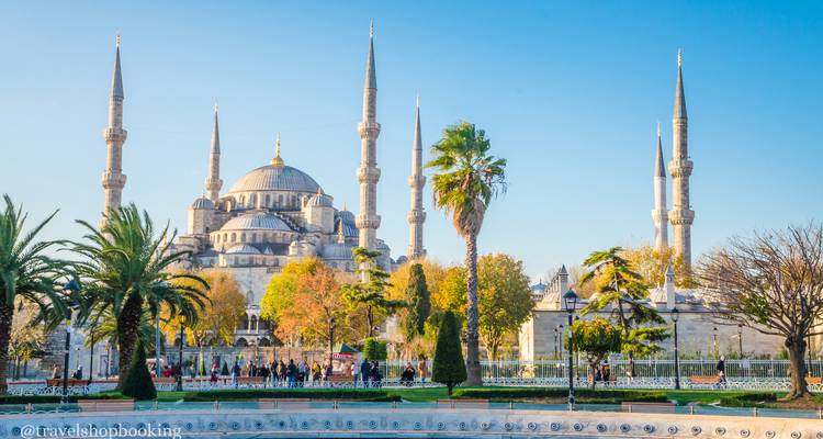 Frontalansicht der Blauen Moschee mit ihren sechs Minaretten, Brunnen und Touristen auf dem angelegten Platz.