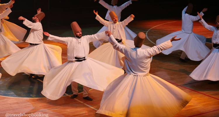 Sufi-Derwische in weißen Gewändern wirbeln anmutig auf der Bühne während einer traditionellen Zeremonie.