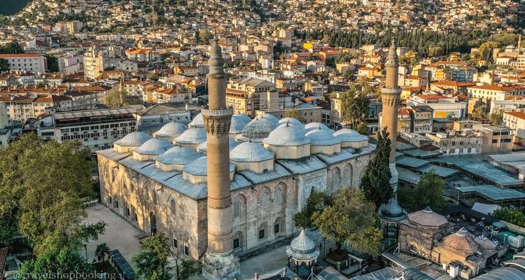 Luftaufnahme der Großen Moschee von Bursa mit Zwillingsminaretten inmitten dichter städtischer Bebauung