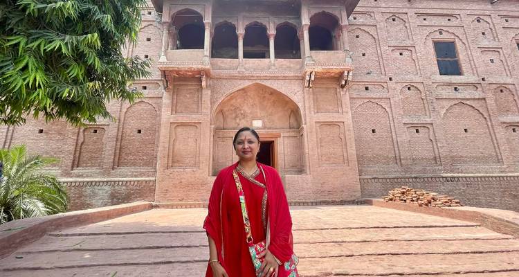 Femme devant un vieux bâtiment en brique avec une arche.