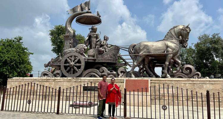 Deux personnes posant devant une grande sculpture de char.
