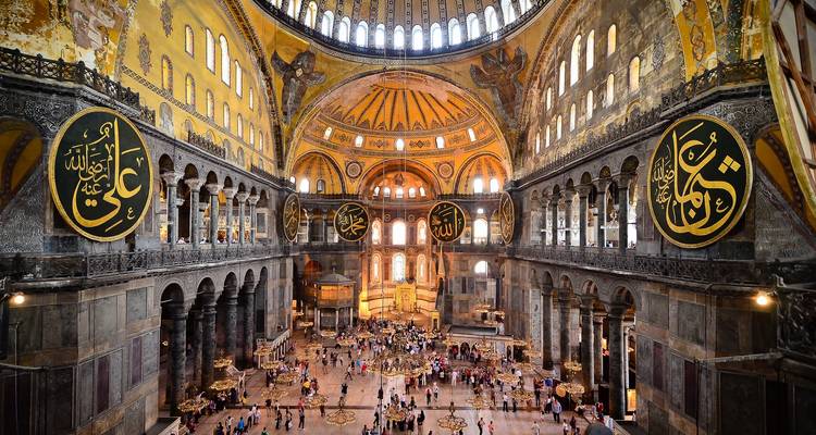 Interior of a grand building with intricate designs.