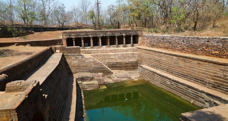 Alter Stufenbrunnen mit Steinstufen, die zu einem Wasserbecken führen.