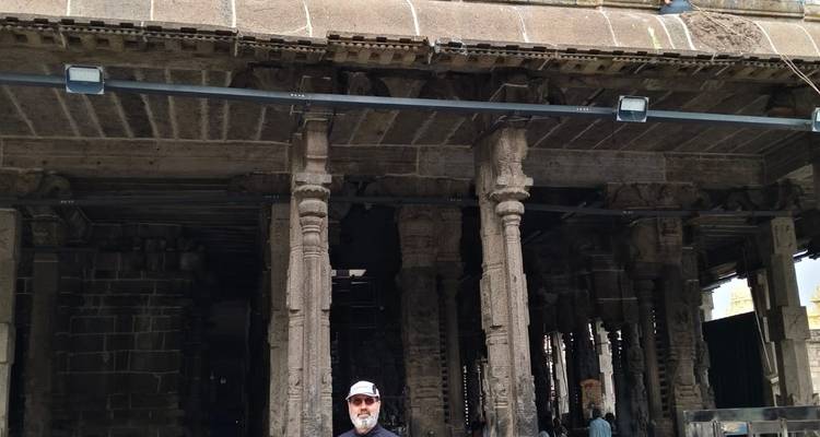 Mann, der vor einem antiken Tempel steht.