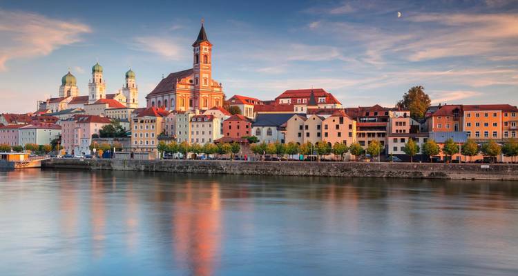 A scenic view of a riverside town with churches and colorful buildings.