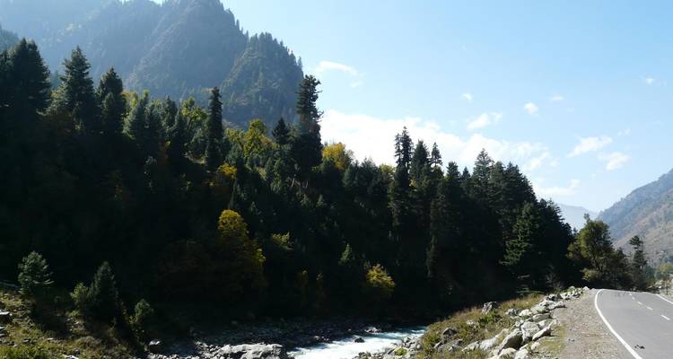 Schilderachtig uitzicht op de bergen met een weg en een rivier eronder.