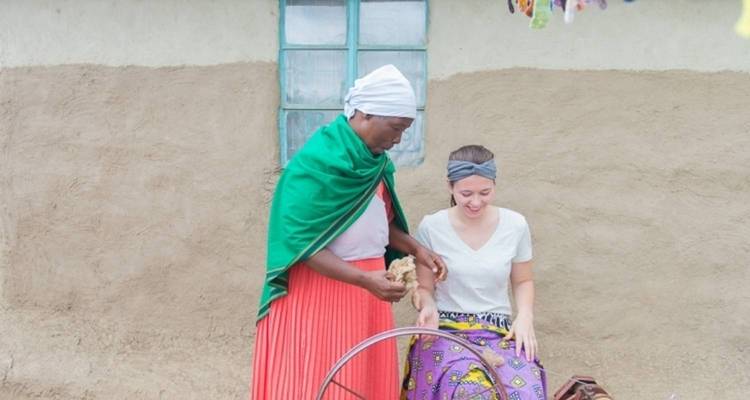 Two people interacting outside a rustic building.