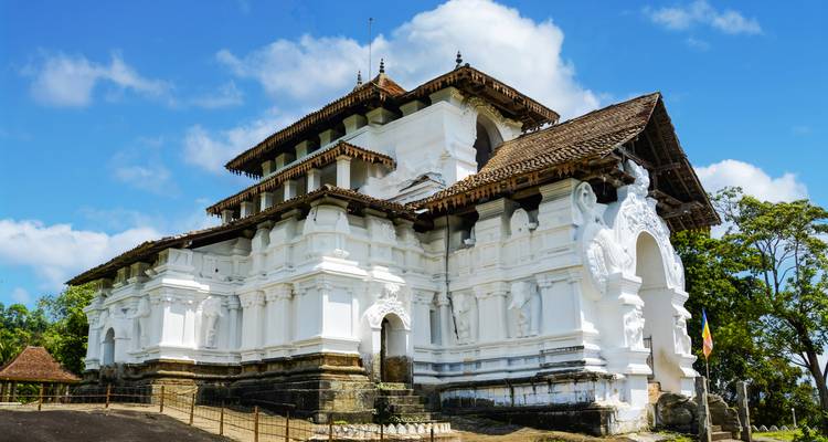 White temple building with intricate carvings under a blue sky