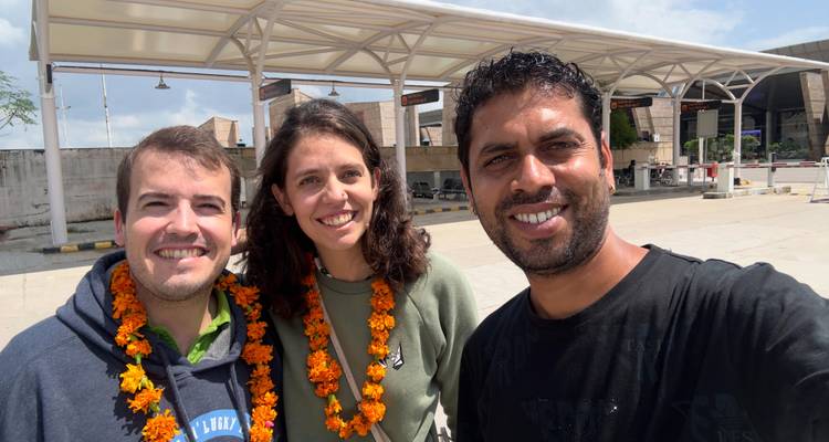 Drie mensen poseren voor een buitenomgeving.