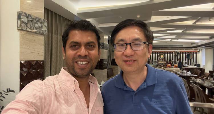 Twee mannen poseren voor een selfie in een restaurant.