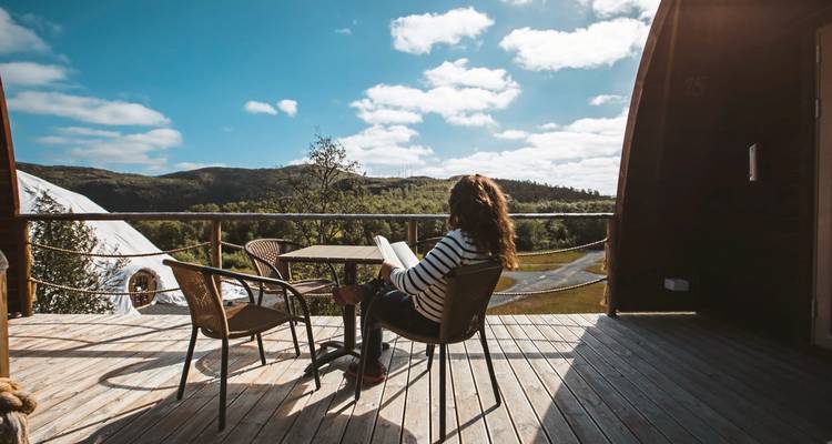 Personne se détendant sur une terrasse avec vue sur un paysage pittoresque.