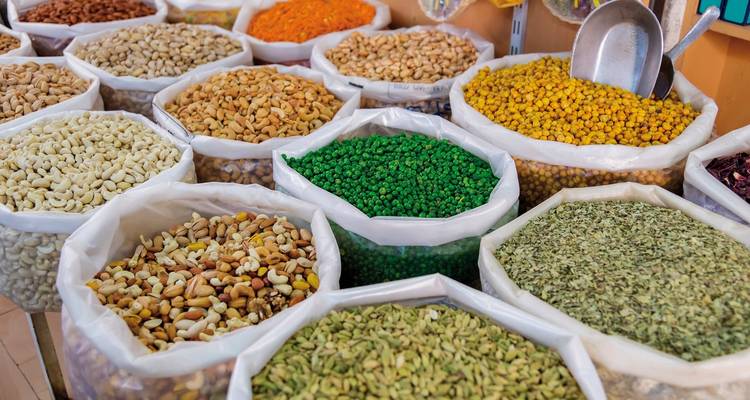Various spices displayed in bags at a bustling market.