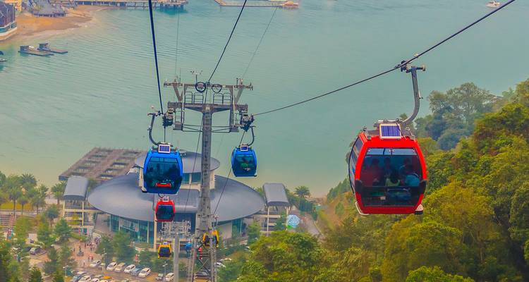 Aerial view of vibrant cable cars over a lake surrounded by mountains.
