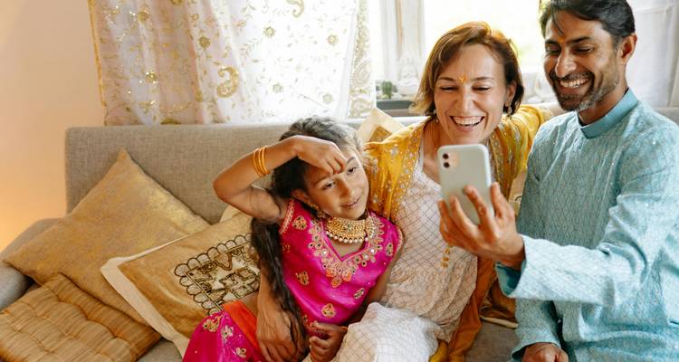 Happy family taking a selfie in colorful traditional attire.