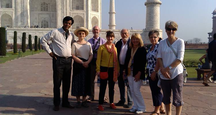 Group of tourists posing in front of the Taj Mahal.