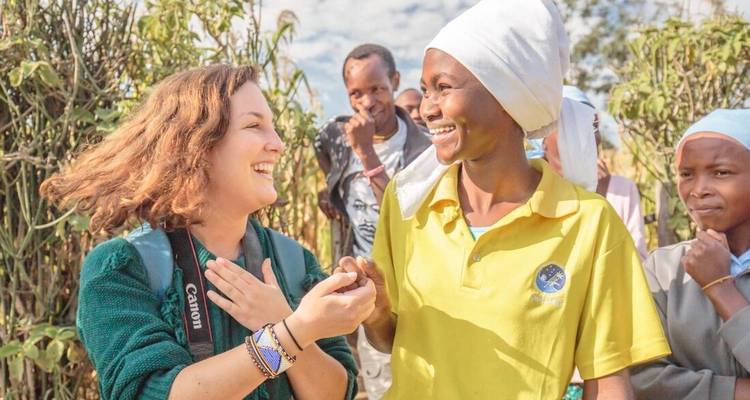 Two women smiling and holding hands in a joyful moment.