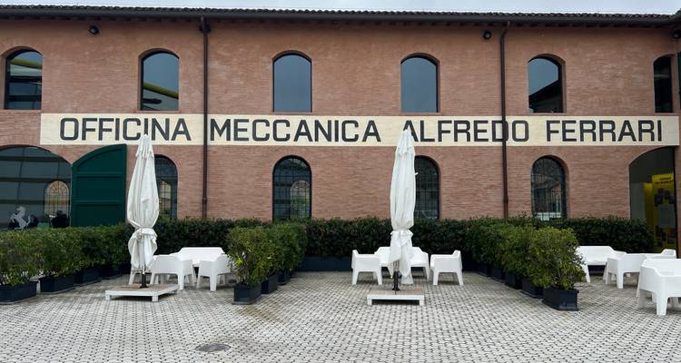 Entrée d'un bâtiment historique avec le nom 'Officina Meccanica Alfredo Ferrari'.