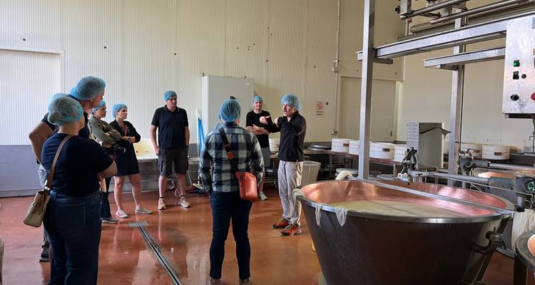 Groupe de personnes lors d'une visite guidée dans une fromagerie.