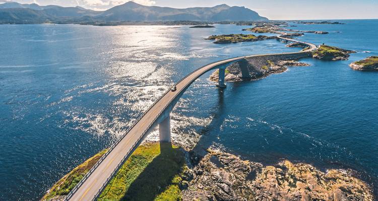 Hängebrücke über türkisfarbenem Wasser mit Inseln.