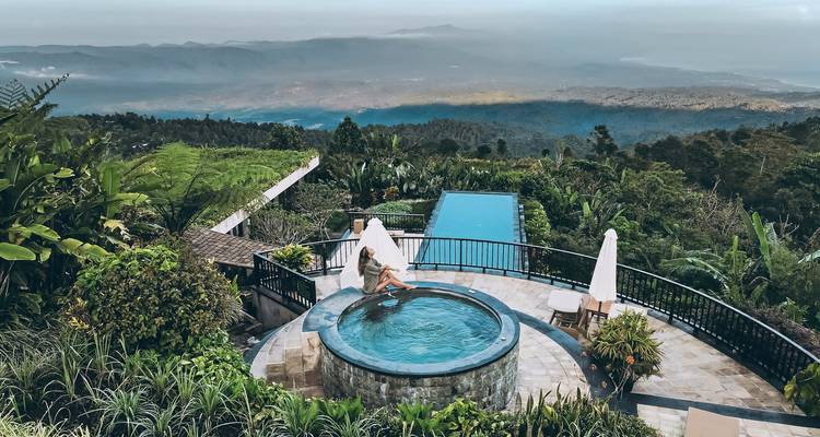 Un couple profitant d'une piscine à débordement avec une vue imprenable sur les montagnes.