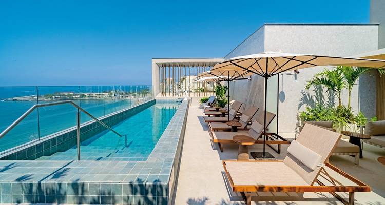 Infinity-Pool mit Meerblick und Sonnenliegen.