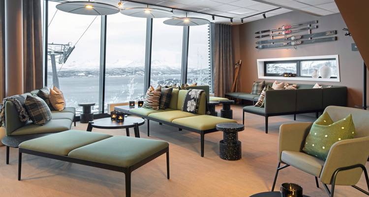 Intérieur moderne avec de grandes fenêtres et vue sur les montagnes.