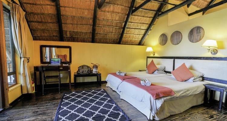 Habitación de hotel rústica con camas gemelas y decoración tradicional.