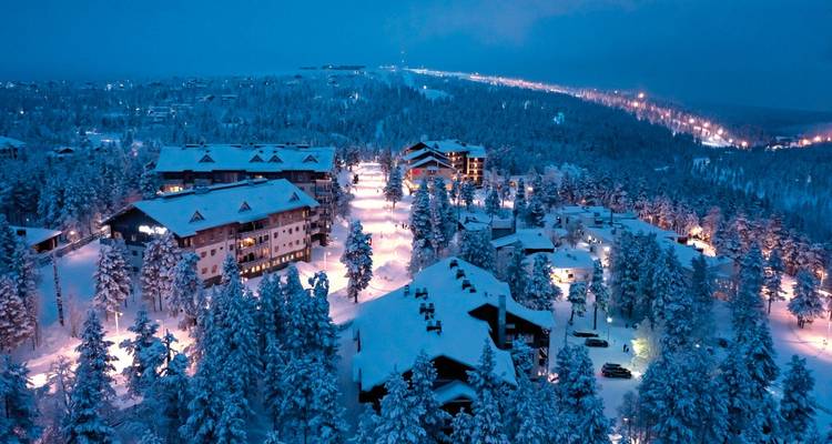 Village enneigé illuminé la nuit.