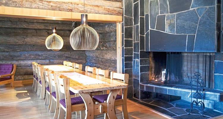 Coin repas avec mobilier en bois et une cheminée.