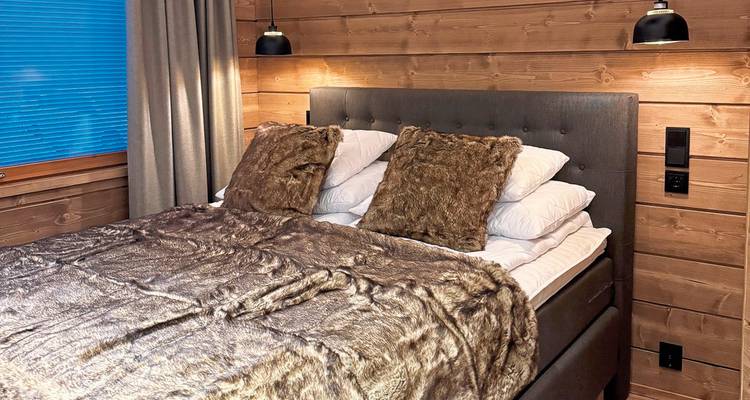 Intérieur douillet d'une cabane avec un lit et des oreillers.