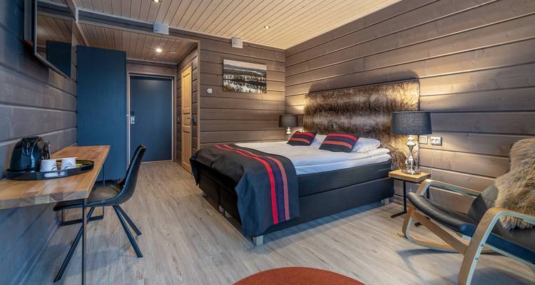 Innenraum einer Holzhütte mit einem Doppelbett.