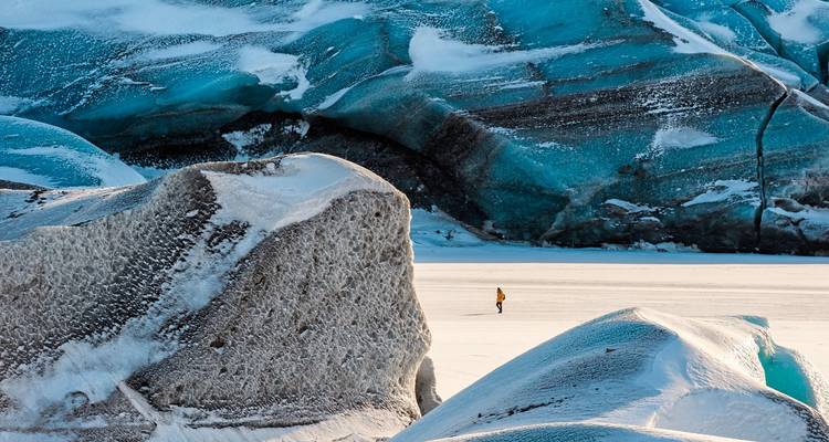 Personne en vêtements d'hiver parmi d'énormes rochers glacés.