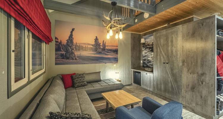 Gemütliches Inneres einer Hütte mit rustikaler Einrichtung und verschneiter Aussicht.