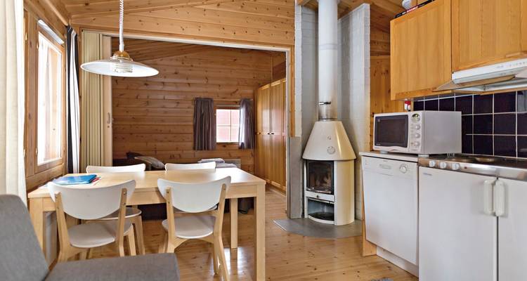 Intérieur en bois simple d'une cabane avec coin repas et cuisine.